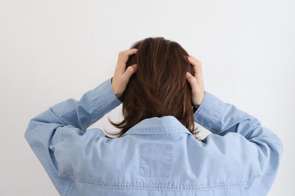 考えが多くてまとまらずに悩んで頭を抱える人の画像