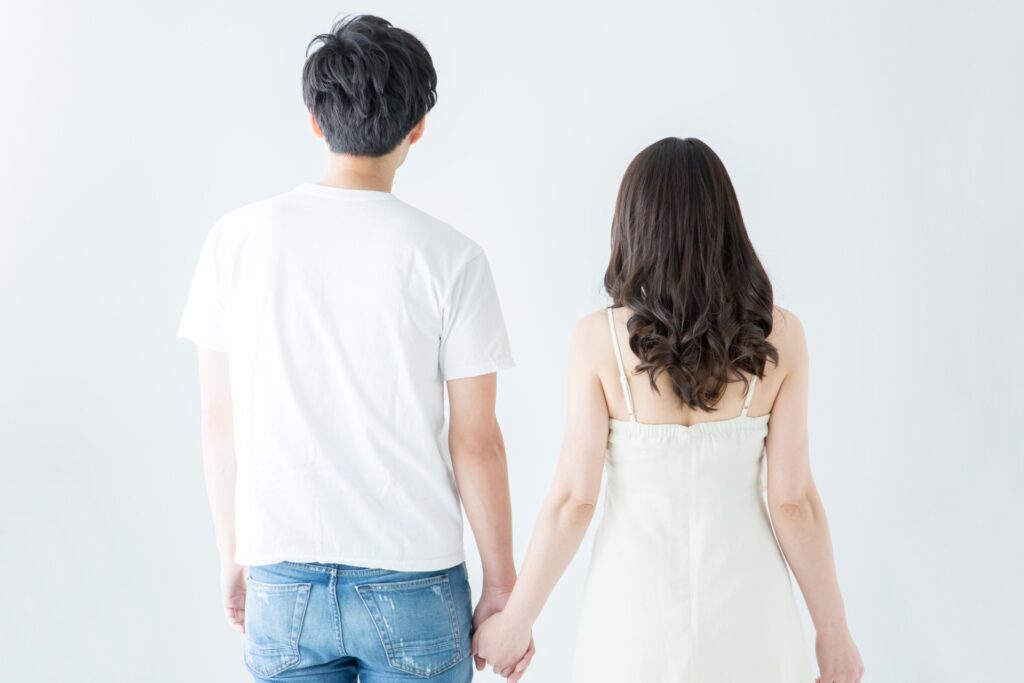 手をつなぐ男女の後ろ姿の画像