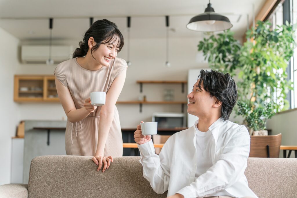 コーヒーを手に話をする男女の画像